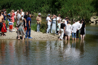 Viele Menschen stehen am Ufer der Rott und im Wasser