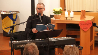 Andi Weis am Piano ein Buch lesend