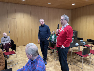 Christian Springer und Dekan Jochen Wilde stehen im Gemeindesaal zur Diskussion bereit.