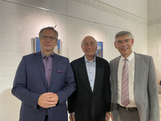 Dekan Jochen Wilde, Dr. Volker Ziegert und Pfarrer Christian Muschler stehen beieinander vor den Gemälden