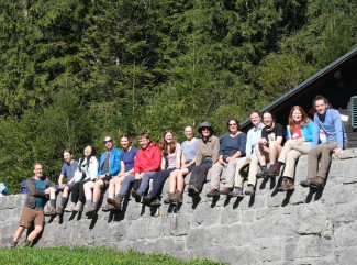 Die Pilgergruppe sitzt auf einer Mauer