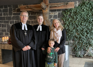 Familie Timm mit Dekan Wilde vor dem Altar der Gnadenkirche in Gangkofen.