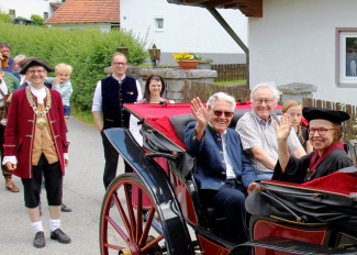 Diakonin Gabi Neumann-Beiler sitzt mit andern Ehrengästen in einer Kutsche und winkt.