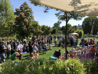 Kinder und Eltern feiern im Garten des evangelischen Kindergartens Pfarrkirchen.