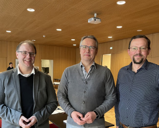 Kircherat Burger, Dekan Wilde und Pfr. Schröder lächeln im Gemeindesaal des Evangelischen Zentrums in die Ka,mera.