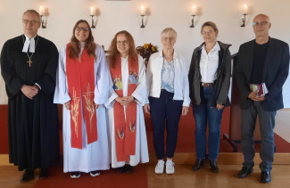 Gruppenfoto der oben genannten Beteiligten vor dem Altar