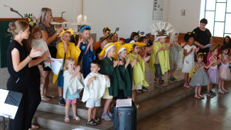 Eine Gruppe Kindergartenkinder präsentieren im Altarraum der Friedenskirche ein Musical.