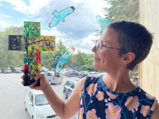 Annalena Hardinge hält ein Glaskreuz ins Gegenlicht.