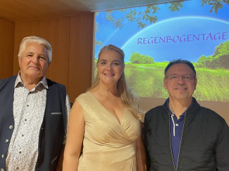 Haselbeck, Sverko und Schmoll vor der Wandprojektion des Gedichtbandes Regenbogentage