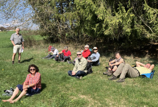 Die Pilgergruppe macht rast auf einer Wiese am Waldrand