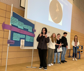 Die Schüler*innen der Klasse 9b präsentieren der gesamten Schülerschaft die Entwicklung des Schulwesens in Ortenburg. (v.l.n.r) Sophie Goldmann, Melanie Hell, Sofia Ring, Kusai Hamado, Luisa Plattner