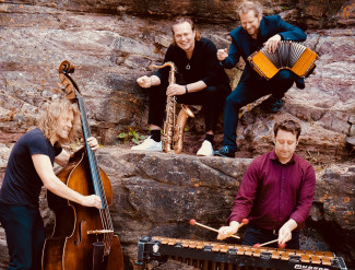 Die vier Musiker von Quadro Nuevo mit ihren Instrumenten an einer Felswand