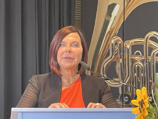 Heide Hesse hält ihre Abschiedrede am Pult in der Turnhalle.