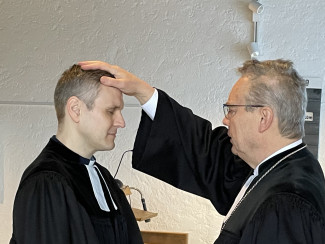 Pfarrer Timm wird von Dekan Wilde durch Handauflegung gesegnet.