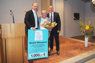 Martin Schmid und Andreas Karau überreichen eine Spende an Sabine Aschenbrenner bei ihrer Verabschiedung in St. Matthäus.