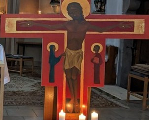 Kreuz mit Kerzen davor