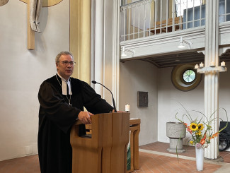Dekan Jochen Wilde am Rednerpult der Stadtpfarrkirche bei seiner Predigt.